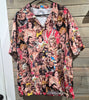 "WWE wrestling scrub top front view on hanger showing all-over print of classic WWF superstars including Hulk Hogan, Ultimate Warrior, and Macho Man Randy Savage – Size Large"