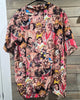 "Back view of WWE wrestling scrub top on hanger with all-over print of classic WWF superstars including Hulk Hogan and Ric Flair – Size Large"